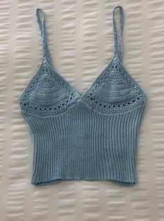 a blue knitted bra top hanging on a wall