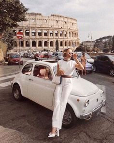 a woman standing next to a white car