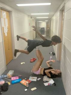 two young men are jumping in the air with their feet on the floor and papers scattered all around them