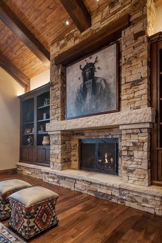 a large living room with stone fireplace and built in bookshelves on the wall