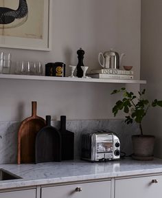 the kitchen counter is covered with dishes, cups, and toaster oven's