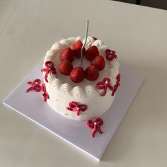 a white cake topped with strawberries on top of a table