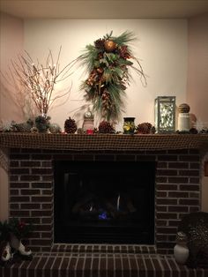 a fireplace decorated for christmas with pine cones and decorations