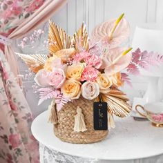 a white table topped with a basket filled with flowers