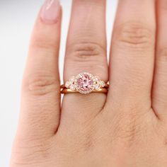 a woman's hand with a pink diamond ring on top of her left hand