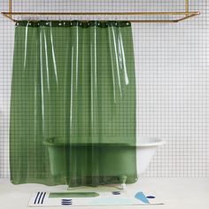 a green shower curtain hanging over a bathtub