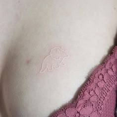 a close up of a woman's breast with a small tattoo on her stomach