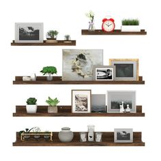 three wooden shelves with pictures and plants on them