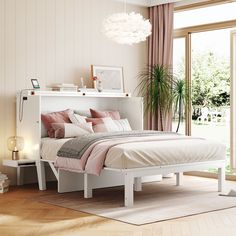 a white bed with pink pillows and blankets