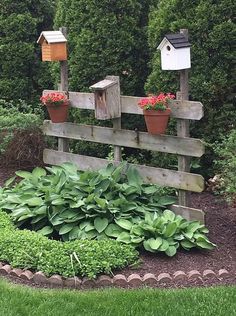 a wooden fence with flowers and bird houses on it's posts in the middle of a garden