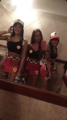 three women in costumes taking a selfie in a mirror with their cell phones up