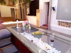 a glass table with rocks and candles on it