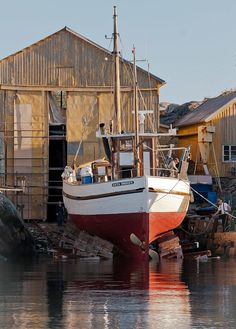 a red and white boat is docked in the water