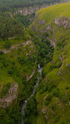 an aerial view of a river running through a lush green valley