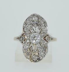 A lovely white and Yellow gold setting houses the array of fine diamonds. The center diamond is an Old European Cut diamond. It measures in at 1/3 of a carat (0.33). The center diamond is in a bezel setting of 18K white gold. Surrounding the OEC Diamond are rose-cut diamonds also set in white gold. The rose cuts are milligrain set into the open work design. The gallery is also done with a lovely openwork to allow for maximum light reflection. The gallery and band are in 18K yellow gold. All of t White Diamond Ring With Rose Cut, Art Deco Diamond White Ring With Bezel Setting, Art Deco White Diamond Ring With Bezel Setting, Exquisite Rose Cut Diamond Anniversary Ring, White Oval Diamond Ring With Single Cut Diamonds, White Diamond Ring With Single Cut Oval Diamonds, White Diamond Ring With Rose Cut For Anniversary, Oval White Diamond Ring With Single Cut Diamonds, White Platinum Diamond Ring With Rose Cut