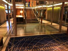 the inside of a cruise ship with stairs leading up and down to the second floor