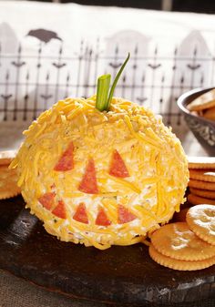 some crackers and cheese are on a wooden platter next to a bowl of crackers