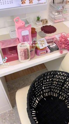 a white desk topped with lots of items and a black basket on top of it