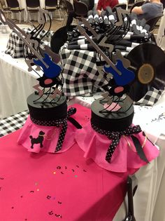 two black and white checkered tables with pink tablecloths, scissors and other decorations