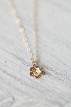 Solid 14k gold cherry blossom charm necklace. A delicate and beautifully detailed charm. Cherry blossoms are a symbolic flower of spring, a time of renewal, and the fleeting nature of life. In Japanese culture the cherry blossom represents the fragility and the beauty of life. Available with a solid gold chain, gold filled chain or as a charm only. Charm comes with a 4mm jump ring, if you would like a spin ring clasp to add to your charm bracelet feel free to contact me.✥  14K Solid gold (charm Dainty Blossom Jewelry For Spring, Dainty Gold Jewelry For Spring, Dainty Blossom Color Jewelry For Spring, Dainty Blossom Flower Jewelry, Spring Gift Gold Jewelry, Dainty Petal-shaped Jewelry With Flower Charm, Flower Pendant Jewelry With Spring Flower Decoration, Spring Flower Pendant Jewelry With Flower Decoration, Spring Flower Pendant Jewelry With Floral Decoration