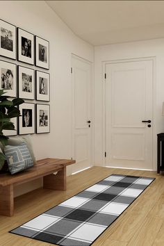 a living room with pictures on the wall and a rug in front of the door