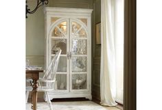 a white china cabinet sitting next to a window