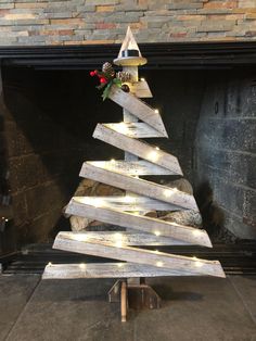 These handmade, spiral effect, rustic, wood strip Christmas trees with lights and tea candle are sure to add warmth and charm to any Christmas Holiday décor this season. This modestly sized tree is 28.5" tall x 19" wide x 6" deep (at the support base) and looks great anywhere!  These trees can be displayed two ways: they can be hung on a wall, or can be placed on a floor, table or counter using the easy to install (without tools) sturdy, ship loose bottom base. The lights and tea candle have simple to operate manual on / off switches and are powered by replaceable CR2032 batteries (included). These trees are made using wood strips that are approximately 1.375" wide x .5" thick and are available in distressed white or brown Shou Sugi Ban (flame burned) finish.  Does not include add on decor Wood Tree Decor, Pallet Christmas Trees, Jenga Crafts, Trees With Lights, Christmas Booth, Christmas Tree With Lights, Tree With Lights