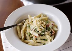 a white bowl filled with pasta on top of a table