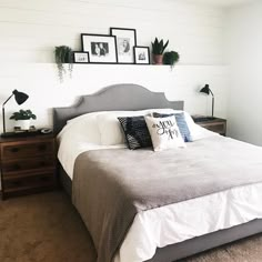 a bed sitting in a bedroom next to two framed pictures on the wall above it