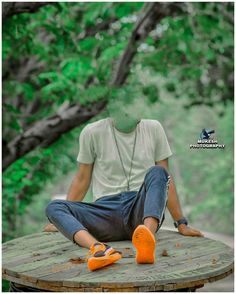 a man sitting on top of a wooden table wearing an orange pair of slippers