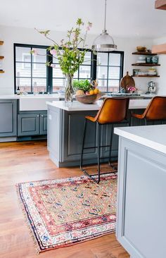 a kitchen with wooden floors and gray cabinets