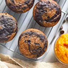 chocolate muffins and macaroni are sitting on a cooling rack next to other foods