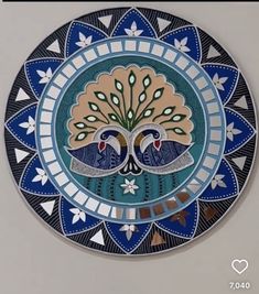 a decorative plate with two peacocks painted on it