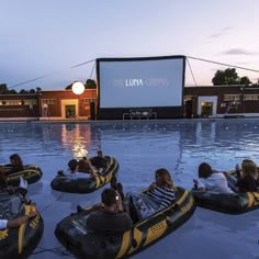 people are riding in bumper boats at the movie theater while others watch them on their cell phones