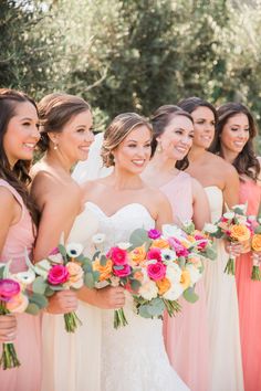 a group of women standing next to each other holding bouquets