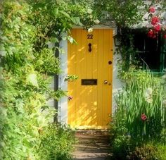 a yellow door in the middle of a garden