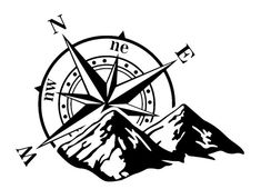 a black and white compass with mountains in the background