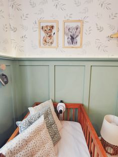 a baby's crib with two pictures on the wall