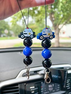 two key chains hanging from the dashboard of a car