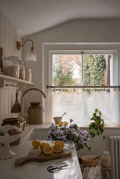 a kitchen counter with flowers and lemons on it