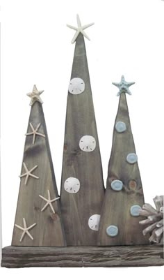 three wooden christmas trees with starfish on them