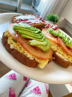 an open faced sandwich with avocado, tomato and lettuce on it