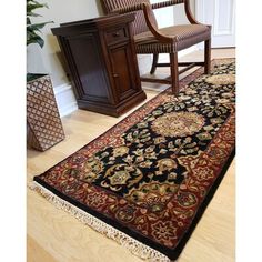 a black and red rug on the floor next to a chair