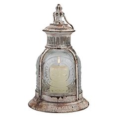 an old fashioned glass lantern with a candle in the center and a metal handle on top