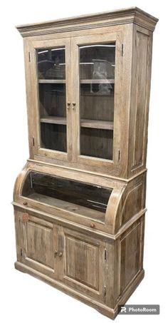 an old wooden hutch with glass doors and drawers on the front, sitting against a white background