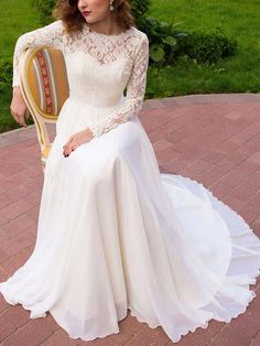 a woman in a white dress sitting on a chair