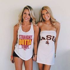 two beautiful young women standing next to each other in short shorts and tank top shirts