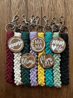 six key chains with different colors and designs on them, one has a button that says mom life