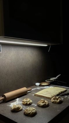 doughnuts are being made on a counter with a rolling pin next to them