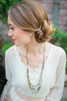 a woman in a white dress with pearls on her necklace